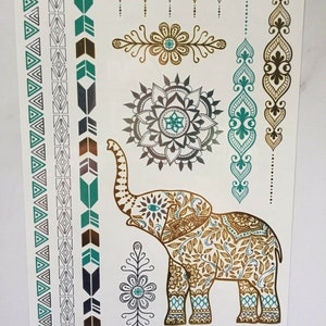 May include: A sheet of temporary tattoos featuring an intricate gold elephant design with teal and silver accents. The sheet also includes several smaller designs, including a mandala, flowers, and geometric patterns. The text "YIH-095" is printed in the bottom left corner.