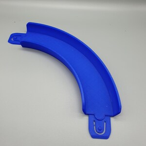 May include: A blue plastic track piece for a toy racing car track. The piece is curved and has a connector on each end.