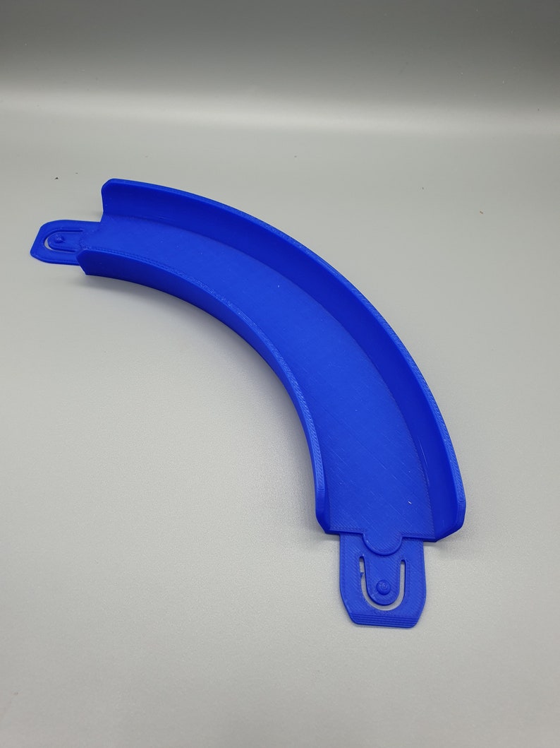May include: A blue plastic track piece for a toy racing car track. The piece is curved and has a connector on each end.