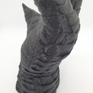 May include: A 3D printed black hand with long, sharp claws. The hand is posed in a grasping motion, with the fingers curled inward.