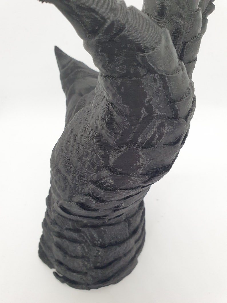 May include: A 3D printed black hand with long, sharp claws. The hand is posed in a grasping motion, with the fingers curled inward.