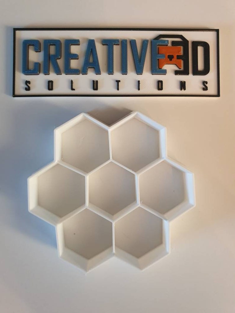 May include: White plastic honeycomb-shaped mold with six hexagonal compartments.