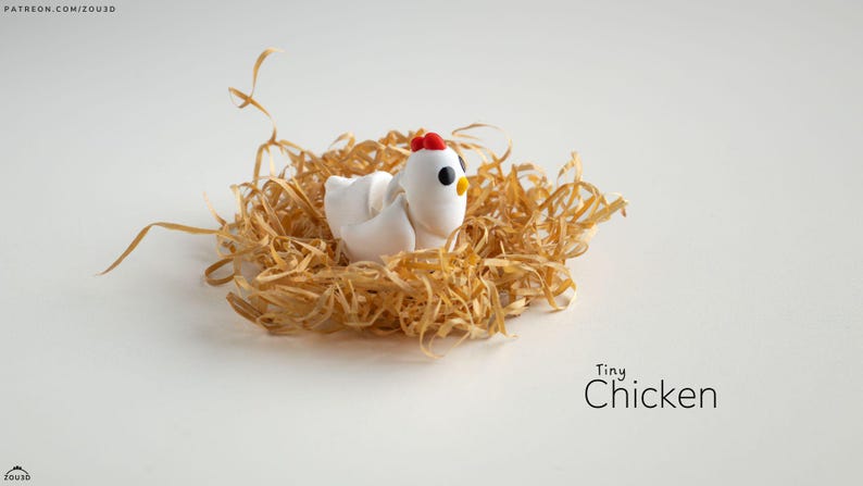 May include: A small white chicken figurine with red accents sits in a nest of shredded paper. The figurine has black eyes and a beak. The text "Tiny Chicken" is written below the nest.