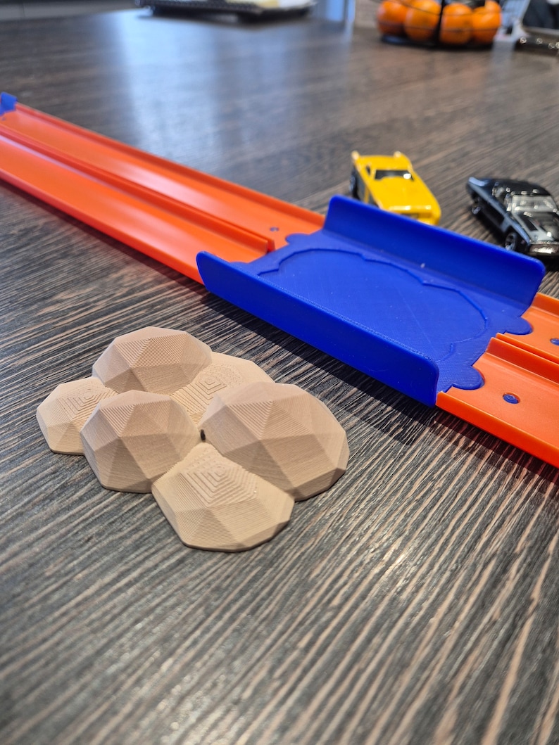 Puede incluir: Un conjunto de formaciones rocosas geom&eacute;tricas marrones impresas en 3D para una pista de carreras de juguetes. Las rocas est&aacute;n dispuestas en un grupo y est&aacute;n hechas de un material texturizado.