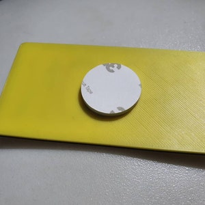May include: A yellow rectangular object with a black border and a white circle with the text "Blue Tape" on it.
