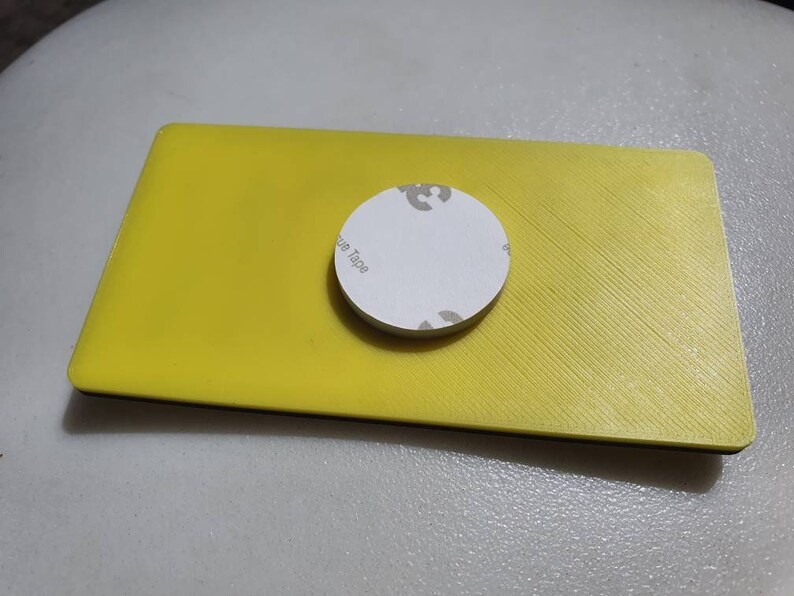 May include: A yellow rectangular object with a black border and a white circle with the text "Blue Tape" on it.