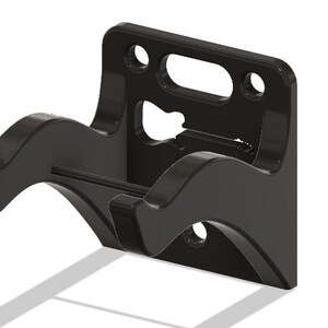 May include: Black wall mount with two curved arms for hanging a guitar. The mount has a cutout in the shape of a guitar.