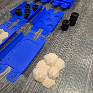 Puede incluir: Un conjunto de piezas de pista de pl&aacute;stico azul para un juego de coches de carreras de juguete. El conjunto incluye piezas de pista rectas, piezas de pista curvas y un puente. Tambi&eacute;n hay cuatro neum&aacute;ticos negros y cuatro rocas marrones.