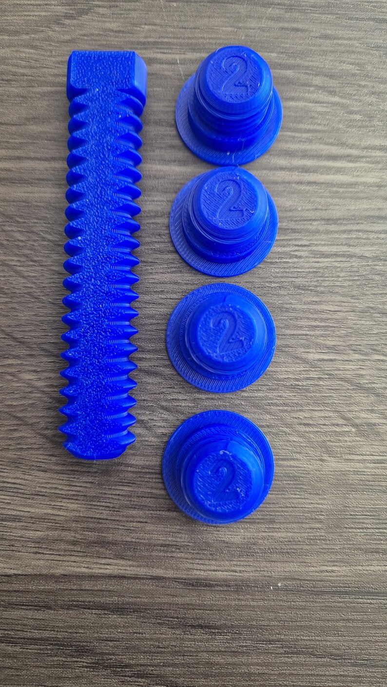 May include: Four blue plastic caps with the number "2" printed on them, and a blue plastic screw with a textured surface.