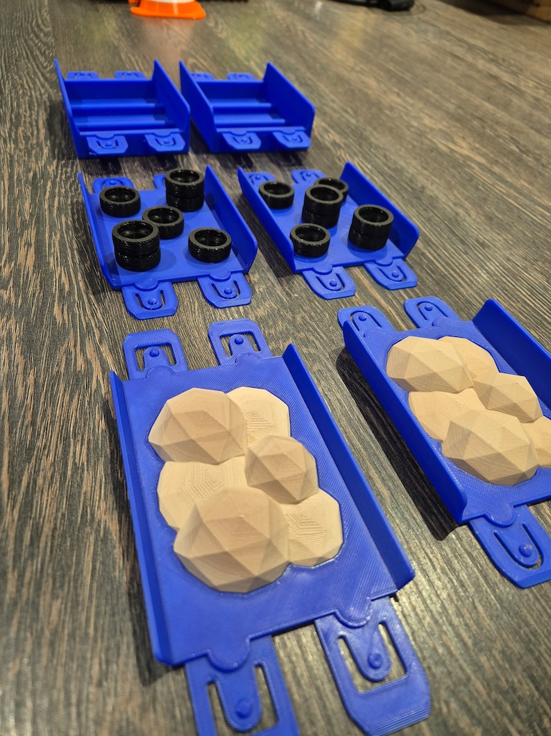 Puede incluir: Un conjunto de piezas de pista de pl&aacute;stico azul para un set de carreras de coches de juguete. Las piezas incluyen pista recta, pista curva y una secci&oacute;n con una superficie texturizada que simula un terreno rocoso.