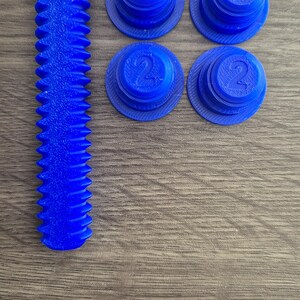 May include: Four blue plastic caps with the number "2" printed on them, and a blue plastic screw with a hexagonal head.