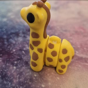 May include: A yellow and brown giraffe figurine with a segmented body. The giraffe has a black eye and a brown nose.