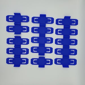 K&ouml;nnte beinhalten: Zw&ouml;lf blaue Plastikclips, angeordnet in vier Reihen zu je drei, auf wei&szlig;em Hintergrund.