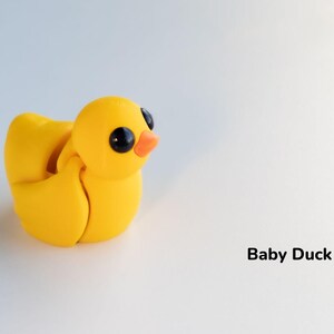 May include: A yellow baby duck toy with black eyes and an orange beak. The duck is made of a soft, pliable material and is designed to be a fun and engaging toy for children.