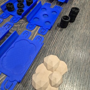 Puede incluir: Piezas de pista de coche de juguete de pl&aacute;stico azul con neum&aacute;ticos negros y rocas de pl&aacute;stico marr&oacute;n.