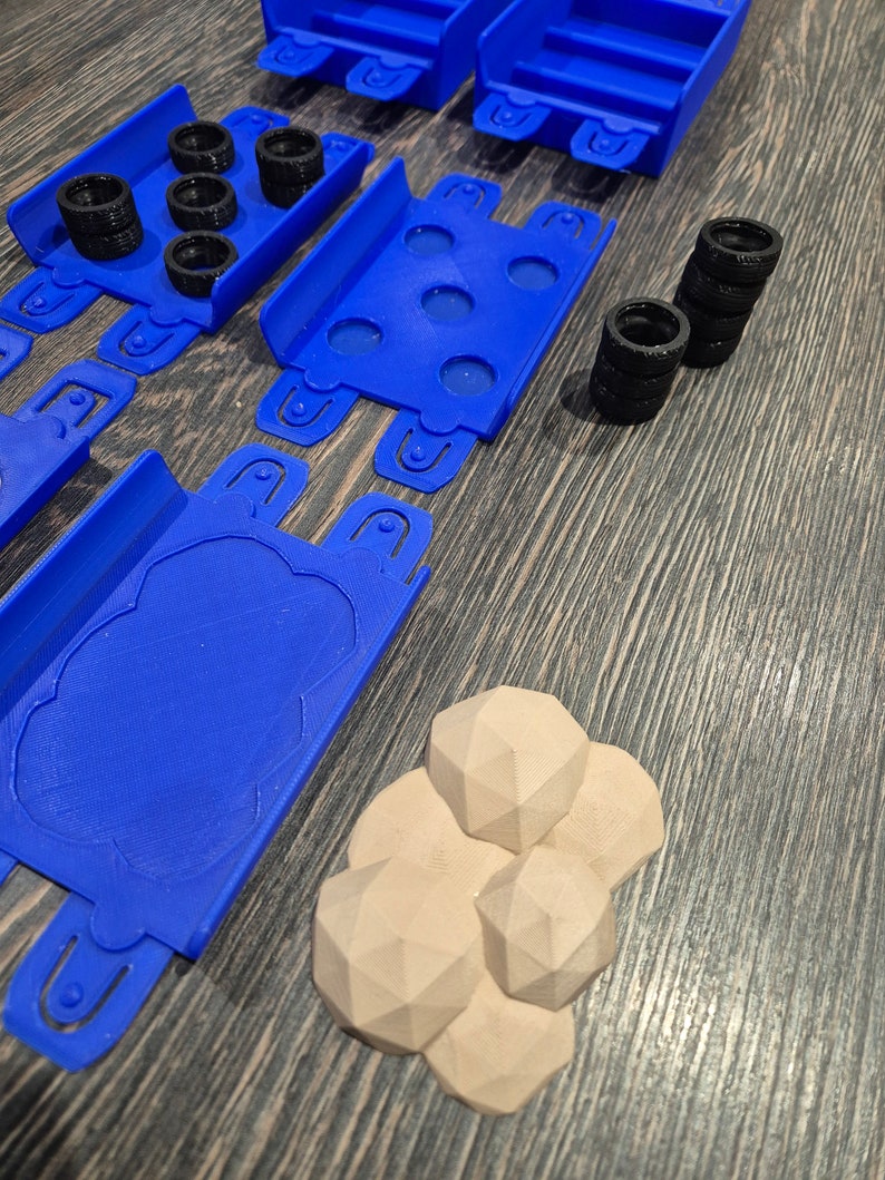 Puede incluir: Piezas de pista de coche de juguete de pl&aacute;stico azul con neum&aacute;ticos negros y rocas de pl&aacute;stico marr&oacute;n.