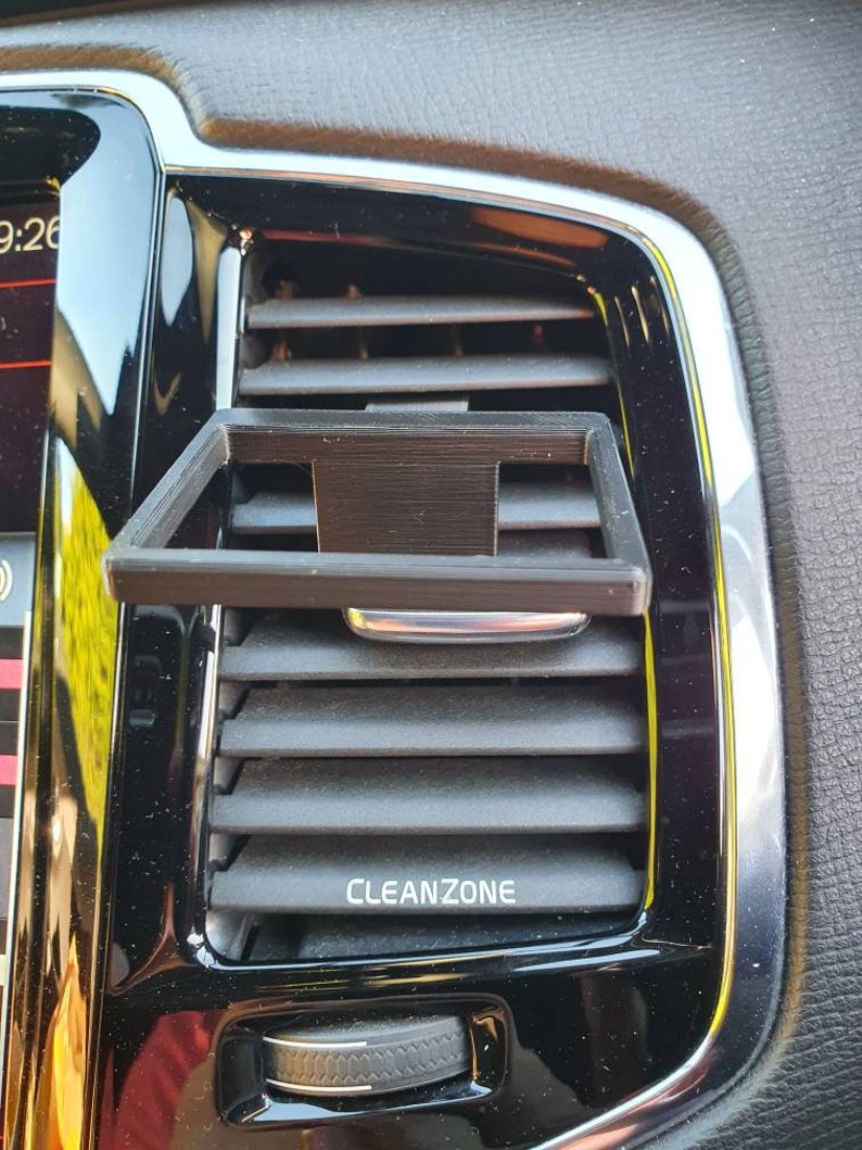 Pu&ograve; includere: Un supporto per telefono nero in plastica per la griglia di ventilazione dell'auto con la scritta "CLEANZONE" stampata sulla griglia.