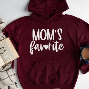 May include: Burgundy hoodie with a white graphic that says "MOM'S favorite" with a small heart in the word favorite.