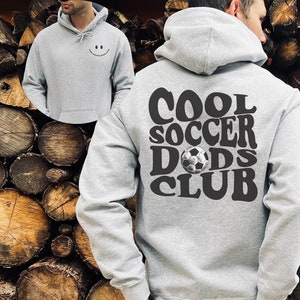Pu&ograve; includere: Felpa con cappuccio grigia con il testo "COOL SOCCER DADS CLUB" in lettere nere e una grafica di pallone da calcio.