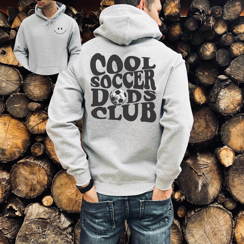 Pu&ograve; includere: Felpa con cappuccio grigia con il testo "COOL SOCCER DADS CLUB" in lettere nere e una grafica di pallone da calcio.