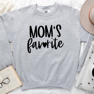 May include: Gray sweatshirt with the text "MOM'S favorite" in black lettering with a small heart in the middle of the word "favorite".