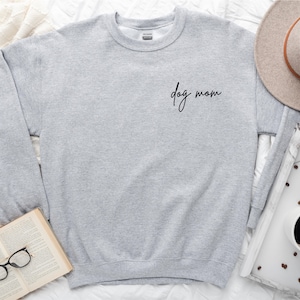May include: A gray sweatshirt with the text "dog mom" in black script on the front.