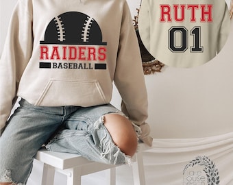 May include: A beige hooded sweatshirt featuring a black baseball graphic with red text that reads RAIDERS BASEBALL. The back of the hoodie displays the name RUTH in red letters above the number 01 in black, both in a collegiate font style.
