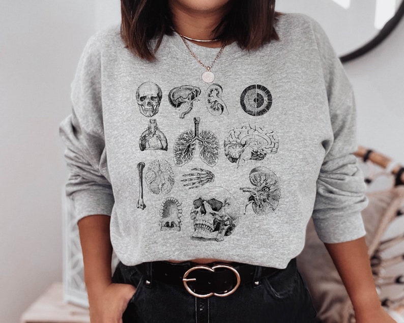 May include: Gray sweatshirt with a black and white anatomical illustration print featuring a skull, brain, heart, lungs, kidneys, and other organs.