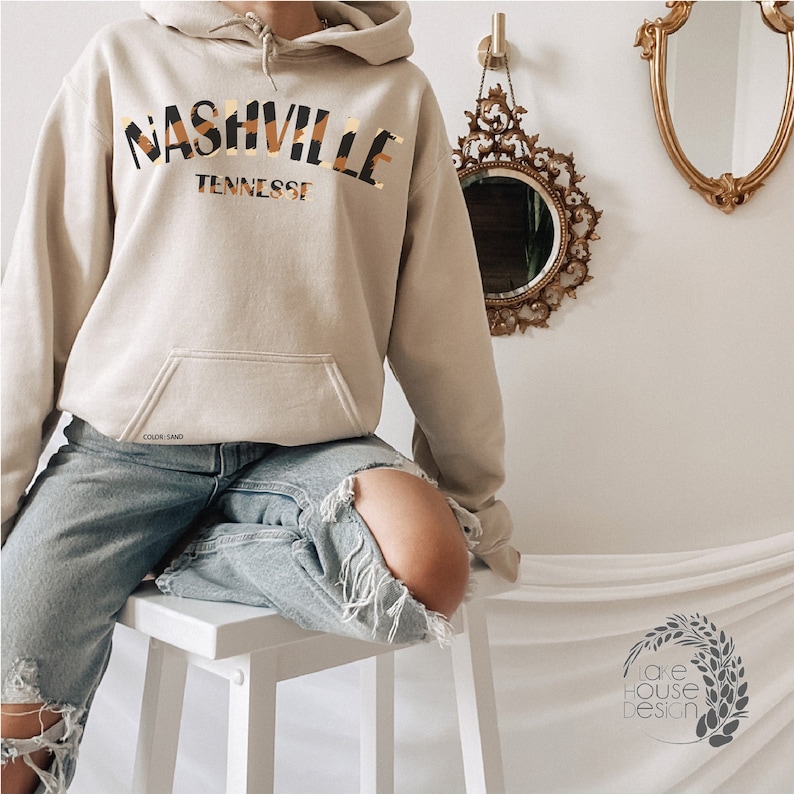 May include: A beige hoodie with a black and brown animal print graphic that says "Nashville Tennessee".