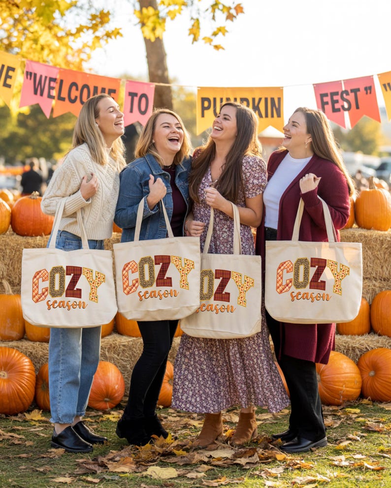 Four women standing in a row, each holding a tote bag with the word "COZY season" printed on it. They are smiling and appear to be enjoying themselves.