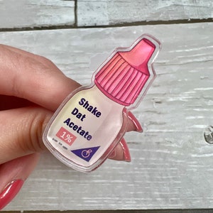 Könnte beinhalten: Eine durchsichtige Plastikflasche mit einem rosa Deckel und einem Etikett mit der Aufschrift "Shake Dat Acetate 1%".
