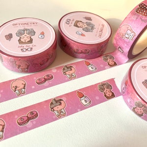May include: Pink and white washi tape with a repeating pattern of a cartoon character wearing glasses and holding an eye chart. The text "OPTOMETRY" and "Jelly Jar Co." is printed on the tape.