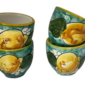 Puede incluir: Juego de cuatro tazas de espresso de cer&aacute;mica con un dise&ntilde;o de lim&oacute;n verde y amarillo. Las tazas est&aacute;n pintadas a mano con una representaci&oacute;n realista de limones y hojas.