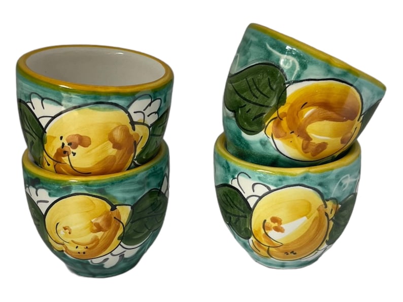 Puede incluir: Juego de cuatro tazas de espresso de cer&aacute;mica con un dise&ntilde;o de lim&oacute;n verde y amarillo. Las tazas est&aacute;n pintadas a mano con una representaci&oacute;n realista de limones y hojas.