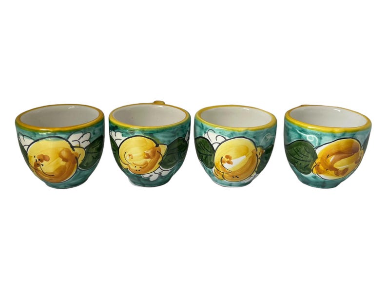 Puede incluir: Juego de cuatro tazas peque&ntilde;as de cer&aacute;mica con un dise&ntilde;o de lim&oacute;n verde y amarillo. Las tazas son blancas por dentro y tienen un borde amarillo.