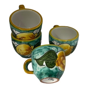 Puede incluir: Juego de cuatro tazas de caf&eacute; de cer&aacute;mica con un dise&ntilde;o de lim&oacute;n verde y amarillo. Las tazas tienen un interior blanco y un asa.