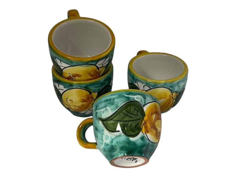 Puede incluir: Juego de cuatro tazas de caf&eacute; de cer&aacute;mica con un dise&ntilde;o de lim&oacute;n verde y amarillo. Las tazas tienen un interior blanco y un asa.