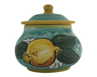 Peut inclure: Un pot en céramique avec un couvercle, peint avec un motif de citron et de feuilles. Le pot est de couleur sarcelle avec des accents jaunes et bruns. Le couvercle a un petit bouton sur le dessus. Le pot mesure environ 13 cm de haut et 10 cm de large.