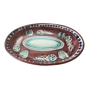May include: An oval ceramic serving platter with a brown background and a green and white design. The design features stylized leaves and flowers.