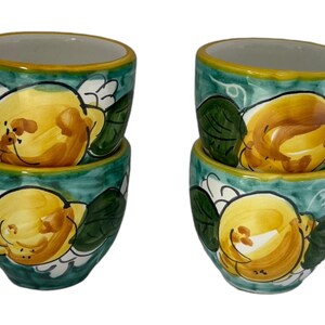 Puede incluir: Juego de cuatro tazas de espresso de cer&aacute;mica con un dise&ntilde;o de lim&oacute;n verde y amarillo. Las tazas est&aacute;n apiladas en pares.