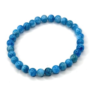 Puede incluir: Un brazalete de cuentas azules. El brazalete presenta cuentas redondas y pulidas en diferentes tonos de azul. Las cuentas est&aacute;n ensartadas en una banda el&aacute;stica, creando un accesorio flexible. El brazalete se muestra sobre un fondo blanco.
