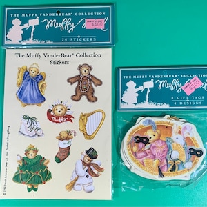 May include: Two packages of Muffy Vanderbear Christmas themed stickers and gift tags. The sticker package has 24 stickers and features a variety of Muffy Vanderbear characters, including a gingerbread Muffy, a snowman Muffy, and a Muffy dressed as an angel. The gift tag package has 8 tags with 4 different designs, featuring Muffy Vanderbear dressed in a masquerade costume.