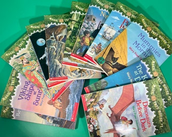 May include: A collection of Magic Tree House books featuring colorful covers with illustrations of various scenes, including a Viking ship, a dinosaur, and a mummy. The books are numbered 1, 2, and 3.