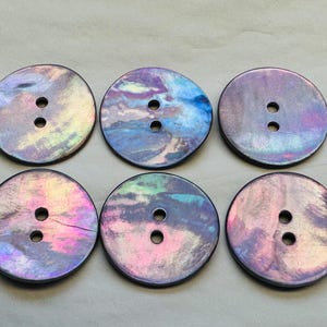 May include: Six iridescent round buttons with two holes each. The buttons have a swirling pattern of blue, purple, pink, and green.