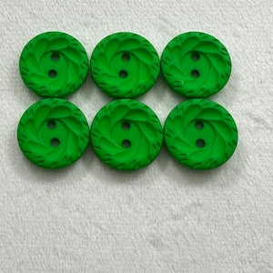 May include: Six green buttons with a swirl design and two holes each.