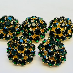 May include: Five round buttons with a cluster of emerald green rhinestones. The buttons are approximately 2.5 cm in diameter.