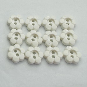 Bottoni bianchi da 11 mm con motivo floreale lucido, da cucire, venduti in set da dodici.