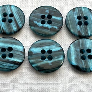 May include: A set of three ceramic mugs with a speckled, matte finish. Each mug features a different color: light blue, cream, and gray. The mugs have a simple, modern design and a comfortable handle.