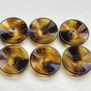 以下が含まれることがあります： 2つ穴の茶色と黒のべっ甲ボタンが6つ