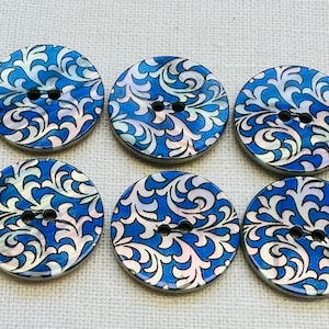Op de afbeelding: Zes ronde knopen met een blauw en wit wervelend patroon. Elke knoop heeft twee zwarte gaten om te naaien. De knopen hebben een parelmoerglans, wat een vleugje elegantie toevoegt aan elk naaiproject.